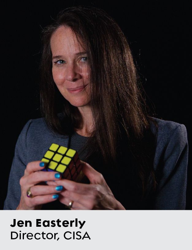Foto de primer plano de una mujer con una chaqueta azul que sostiene un cubo de Rubik