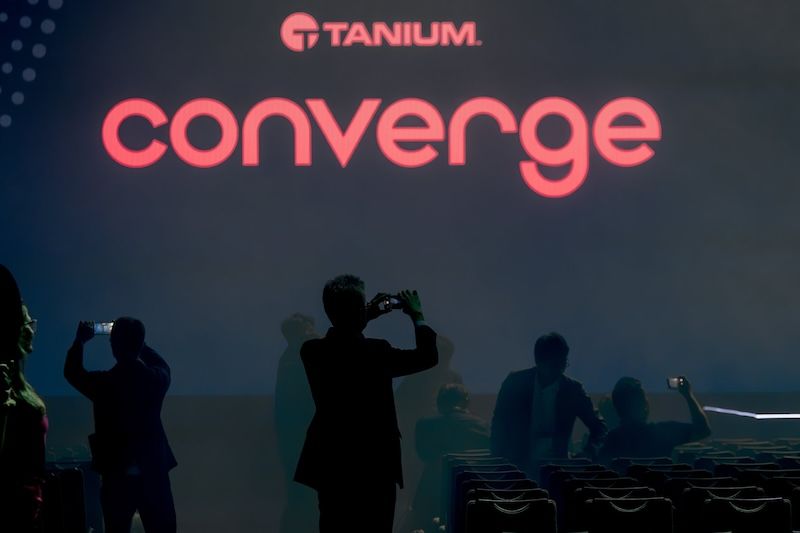 Escenario de CONVERGE 2024 con el logotipo de Tanium y los asistentes