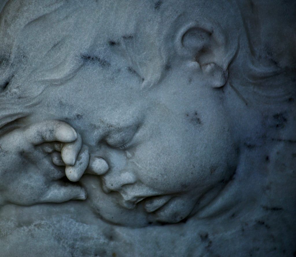 Escultura en piedra de un querubín durmiente