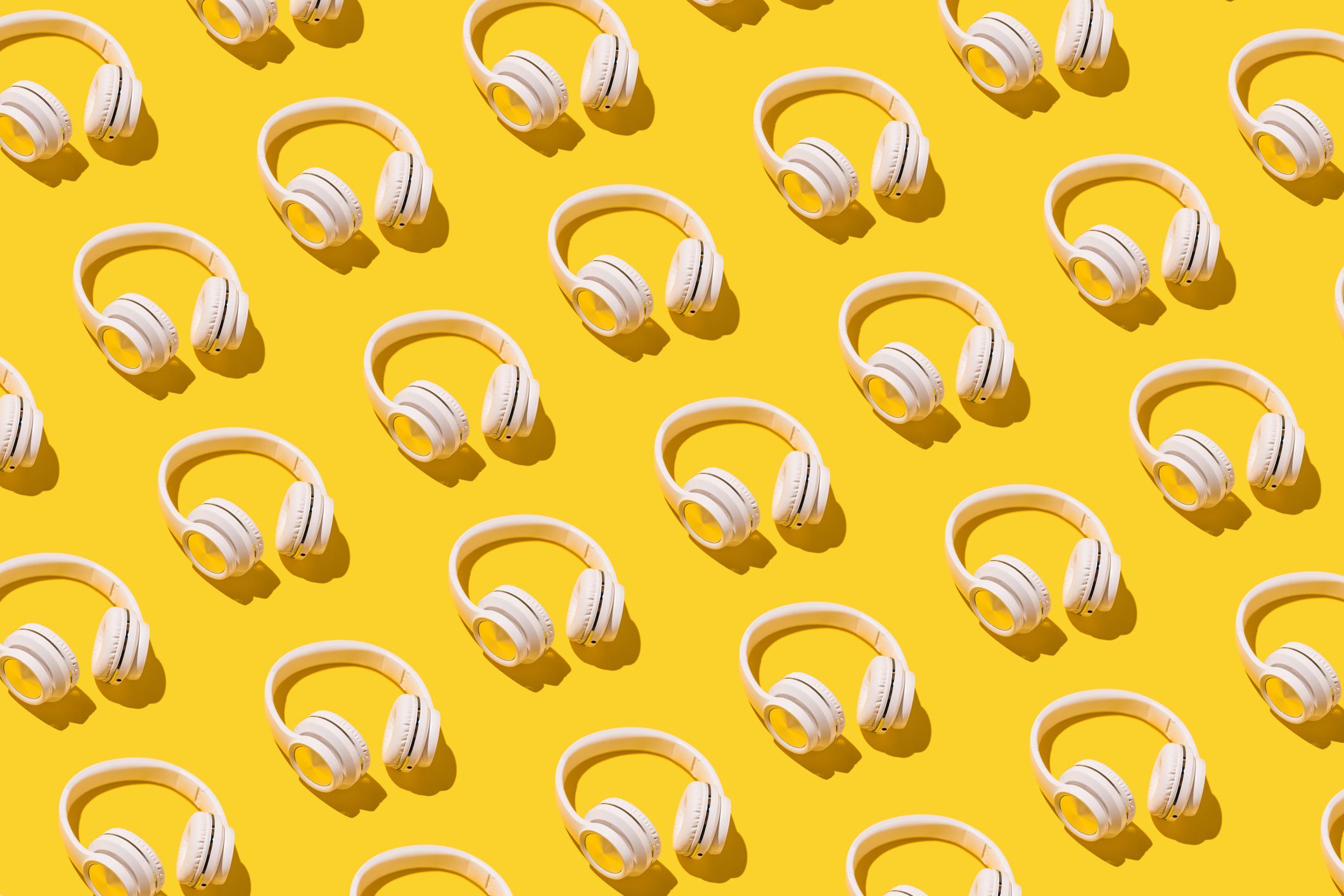 Una imagen de auriculares en filas diagonales sobre un campo amarillo brillante.