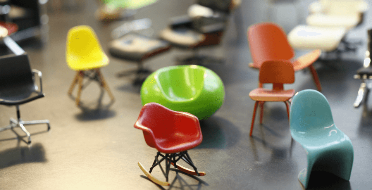Una colección de sillas de diseñador en miniatura con formas onduladas y colores brillantes.