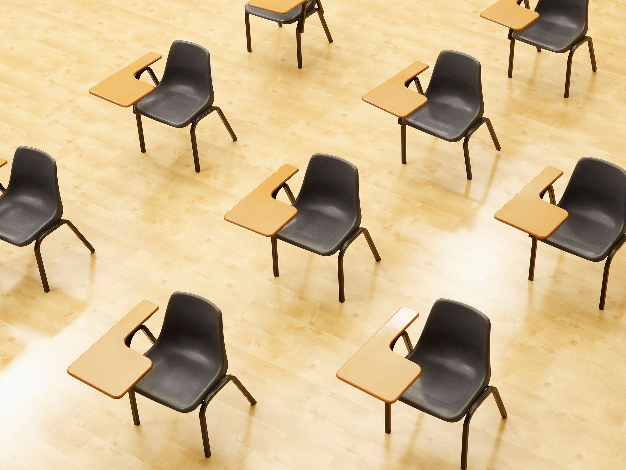 Filas de escritorios alineados en diagonal en un aula vacía.