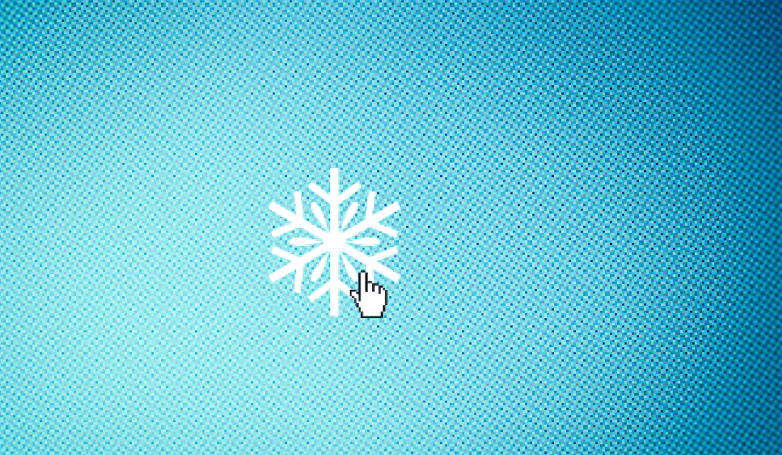 Una imagen de un copo de nieve blanco aparece en una pantalla de computadora azul con un pequeño cursor en forma de mano a punto de hacer clic en él.