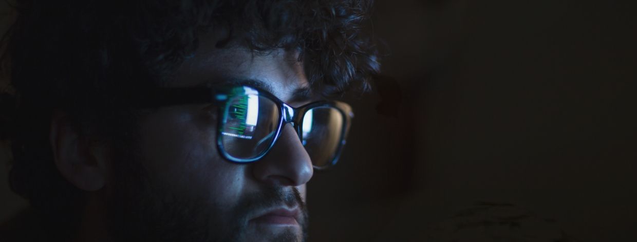 imagen de archivo: rostro en una habitación oscura iluminado por el brillo de un monitor de computadora