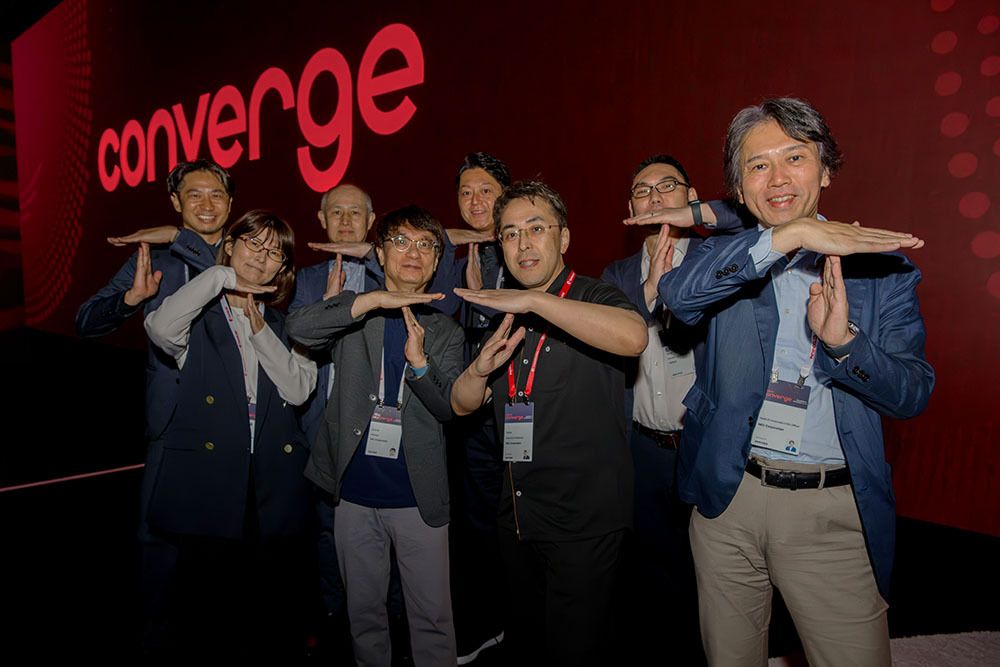 Foto de 8 personas usando sus brazos para formar la letra T